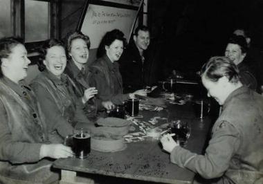 British Women's Land Army girls enjoying a beer with the 44th Bomb Group in the enlisted men's recreation centre and pub at Shipdham Airbase. (Digital archive reference MC 371/046)